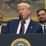 President Donald Trump speaks as Cody Campbell, left, and professional golfer Bryson DeChambeau listen during an event for the signing of an executive order restarting the Presidential Fitness Test in public schools, Thursday, July 31, 2025, in the Roosevelt Room of the White House in Washington.